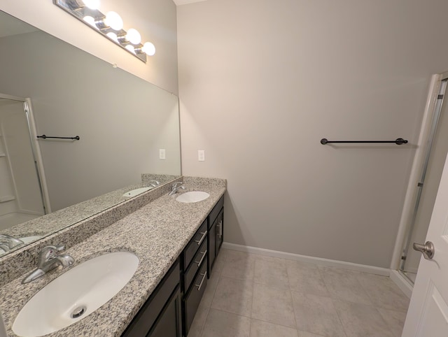 full bath featuring tile patterned flooring, a sink, baseboards, and double vanity