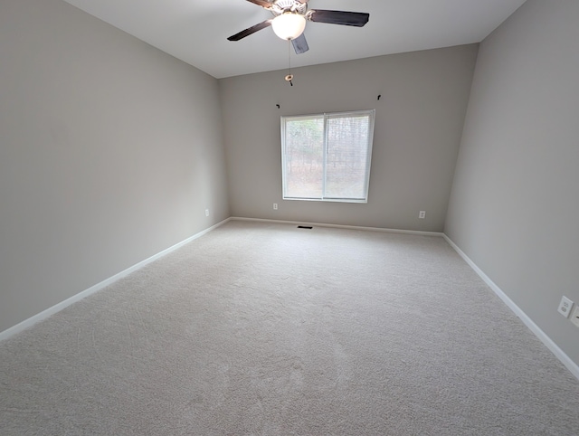 unfurnished room with carpet flooring, a ceiling fan, and baseboards