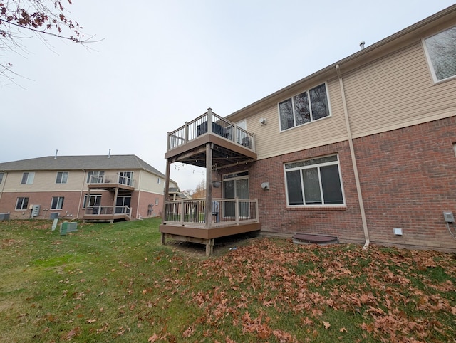 back of house with a yard, a deck, and brick siding