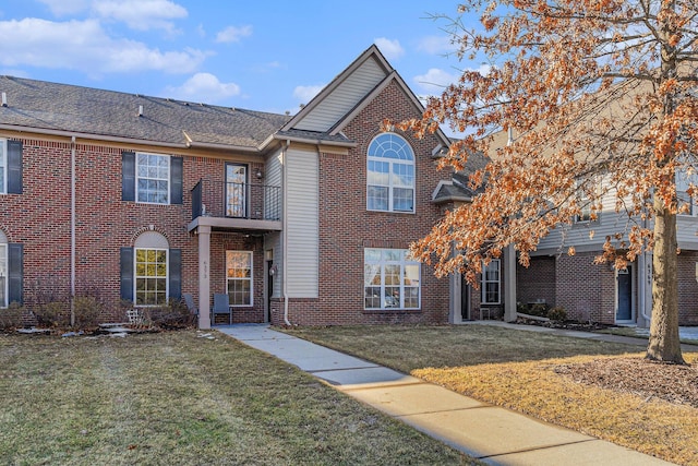 view of front facade featuring a front yard and brick siding