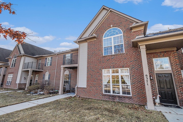 traditional home featuring brick siding and a front lawn