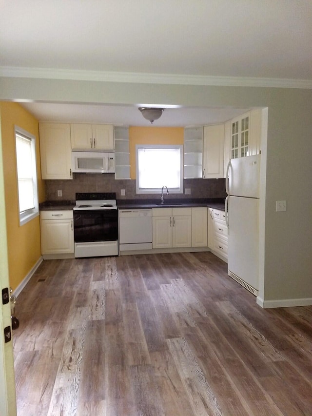 kitchen featuring white appliances, a sink, a healthy amount of sunlight, open shelves, and dark countertops