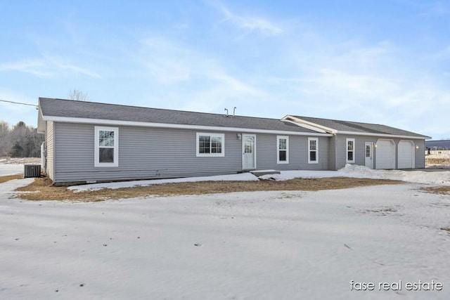 view of front of property with an attached garage and central AC unit