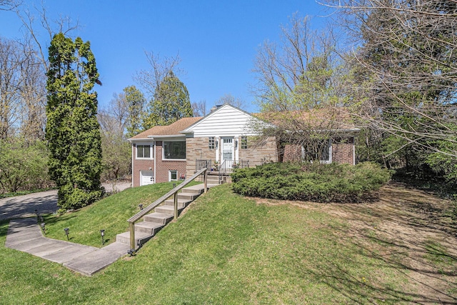 view of front of house featuring a garage, brick siding, and a front yard