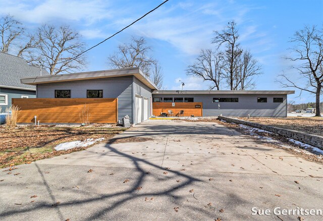 exterior space featuring concrete driveway, a garage, and fence