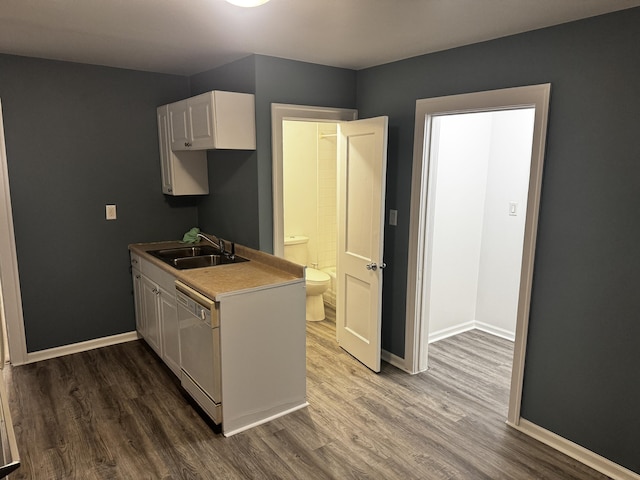 kitchen featuring dishwasher, wood finished floors, a sink, and baseboards