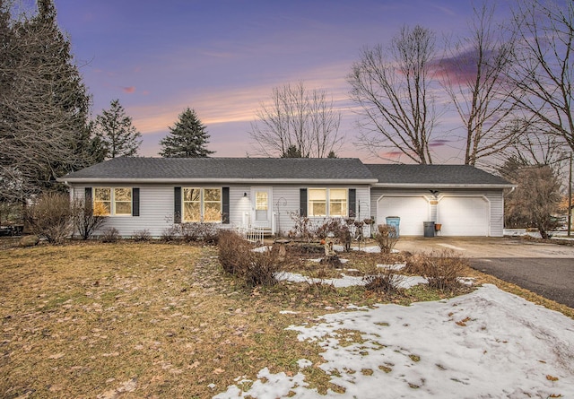 ranch-style home with aphalt driveway and a garage