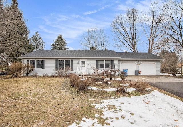 ranch-style home with an attached garage and aphalt driveway