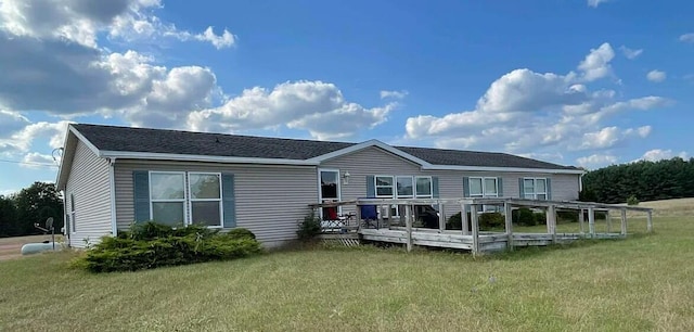 rear view of house featuring a lawn and a wooden deck