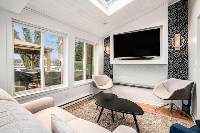 interior space with lofted ceiling with skylight, baseboard heating, wood ceiling, and wood finished floors