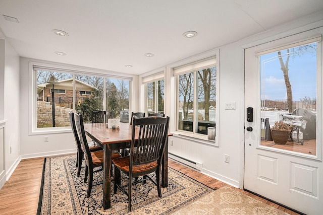 dining room with recessed lighting, a baseboard radiator, baseboards, and light wood finished floors