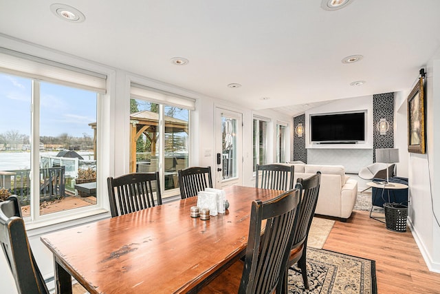 dining room featuring recessed lighting, baseboards, lofted ceiling, and light wood-style floors