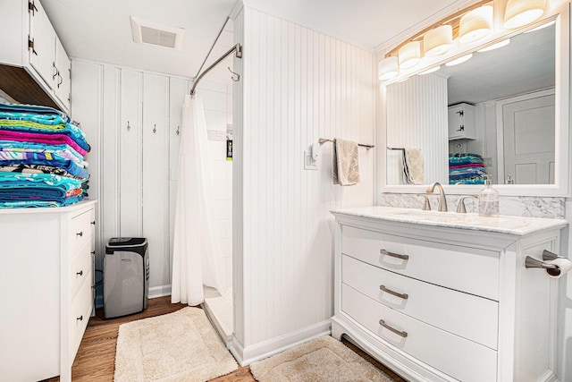 full bathroom with visible vents, a stall shower, vanity, and wood finished floors