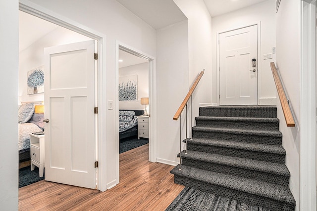 staircase with baseboards and wood finished floors