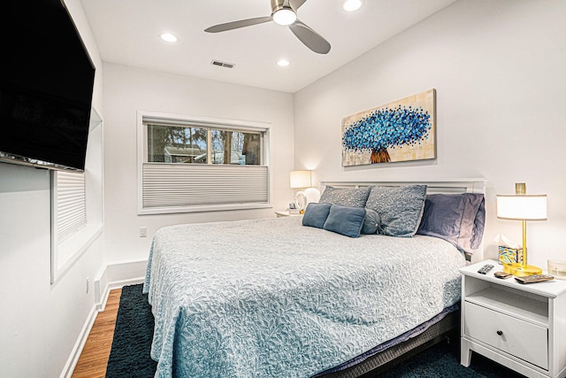 bedroom with a ceiling fan, wood finished floors, visible vents, baseboards, and recessed lighting