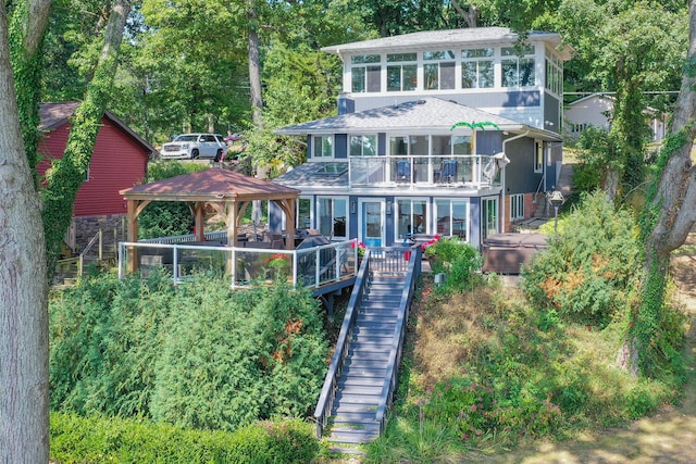 back of house featuring stairs, a gazebo, and roof with shingles