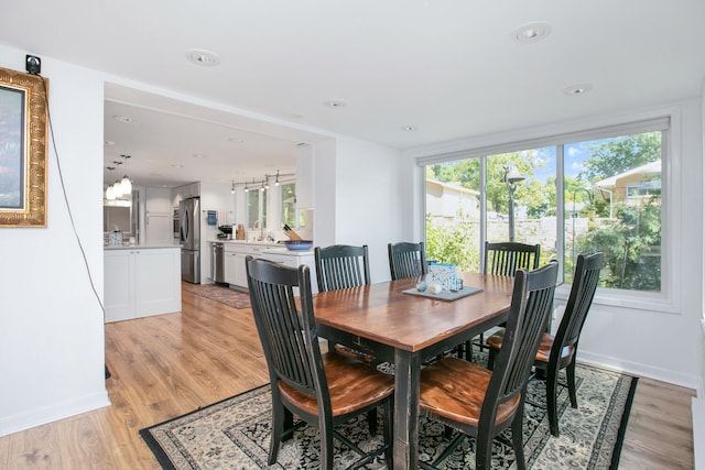 dining space with light wood-style flooring, recessed lighting, and baseboards