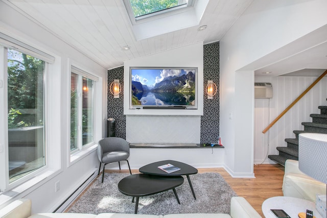 sitting room with lofted ceiling with skylight, plenty of natural light, wood finished floors, and baseboard heating