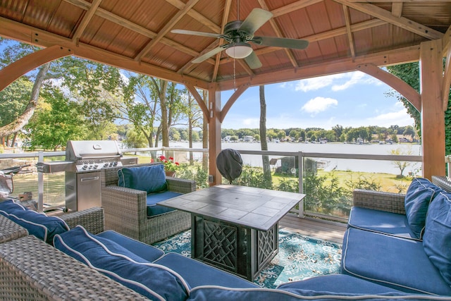 view of patio with outdoor lounge area, a gazebo, a ceiling fan, and a water view