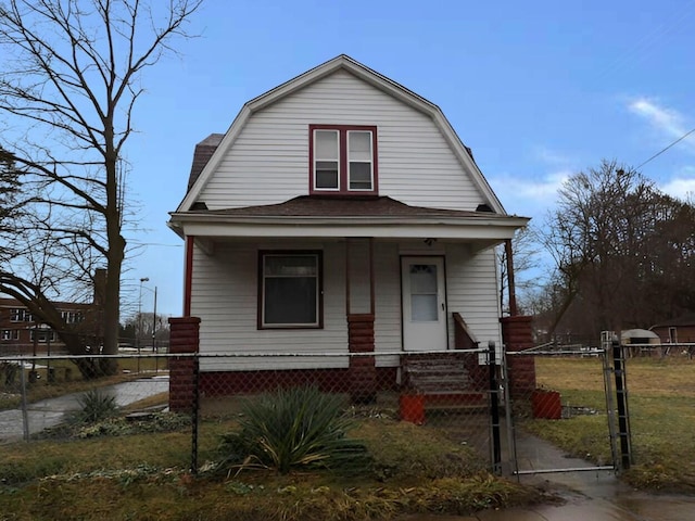 dutch colonial with a porch, a fenced front yard, a gambrel roof, roof with shingles, and a gate