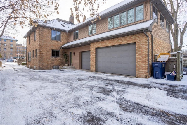 view of front of property with a garage, driveway, and brick siding