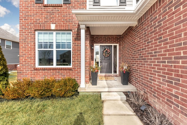 entrance to property featuring brick siding