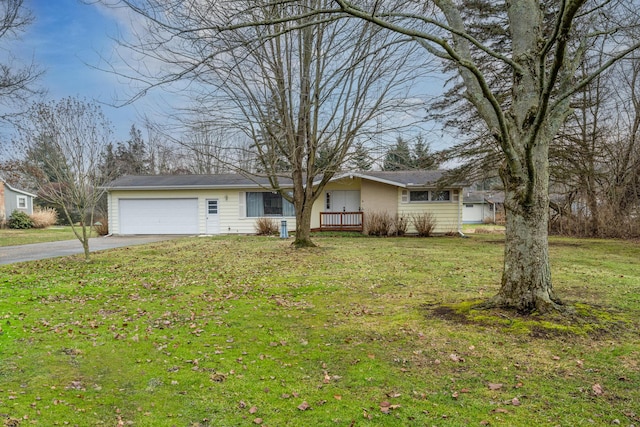 single story home featuring a front yard, concrete driveway, and an attached garage