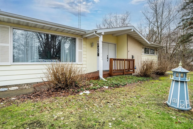 exterior space featuring brick siding and a front yard