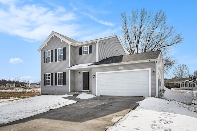 traditional-style house featuring an attached garage, driveway, and fence