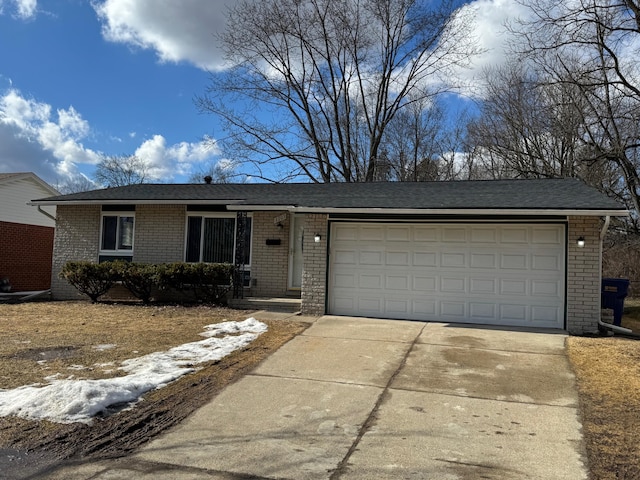 single story home featuring a garage, driveway, and brick siding