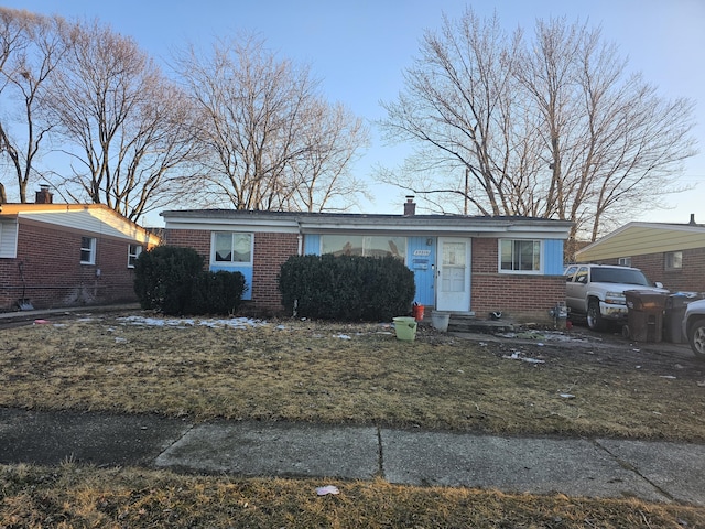 view of front of house with brick siding and a chimney