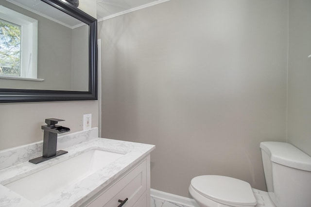 half bath featuring baseboards, toilet, ornamental molding, marble finish floor, and vanity