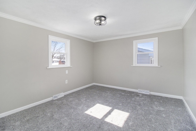 carpeted spare room featuring visible vents, crown molding, and baseboards