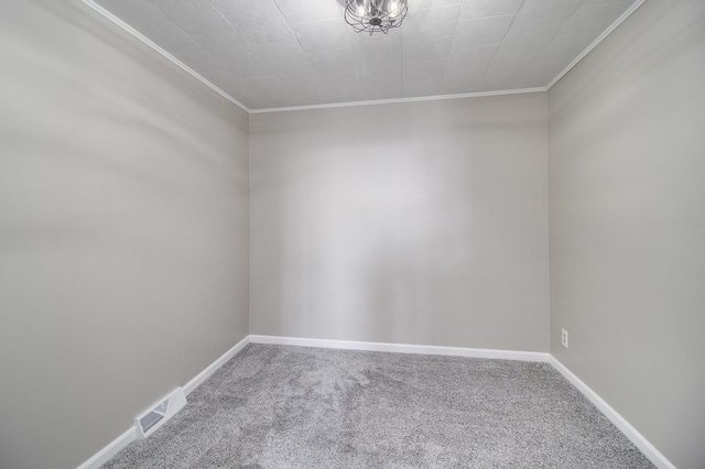 carpeted spare room featuring baseboards, visible vents, and ornamental molding