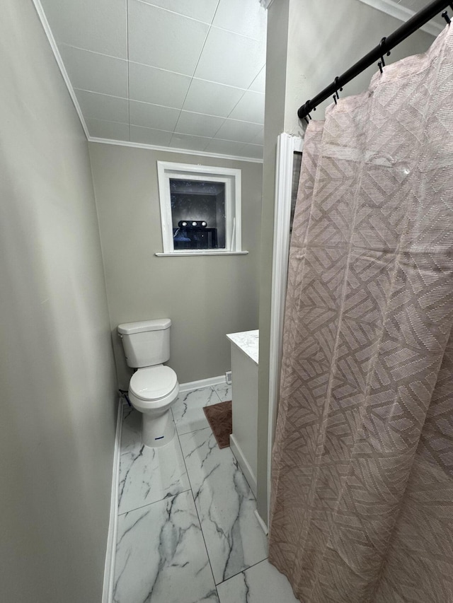 bathroom with toilet, vanity, baseboards, marble finish floor, and crown molding