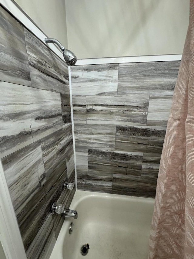 bathroom with shower / bath combo with shower curtain