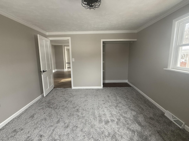 unfurnished bedroom with ornamental molding, carpet flooring, visible vents, and baseboards