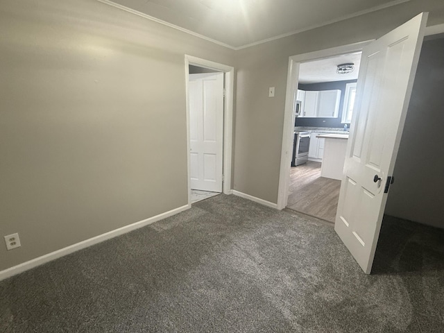 carpeted spare room with ornamental molding and baseboards