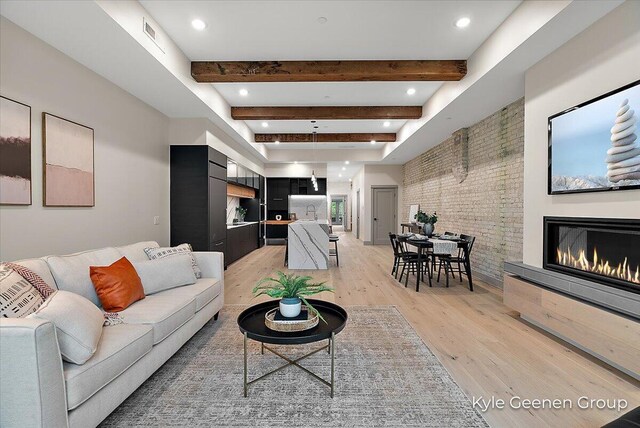 52 E 8th St Ste 210, Holland, MI 49423 - living room with light wood-style flooring, beam ceiling, a glass covered fireplace, brick wall, and recessed lighting