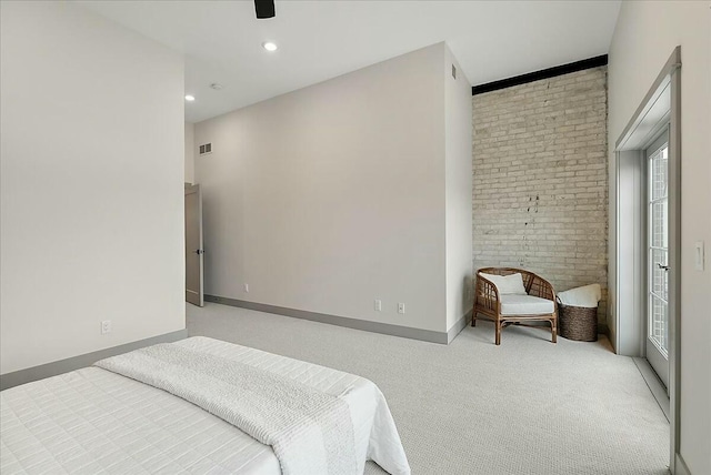 bedroom featuring light colored carpet, baseboards, multiple windows, brick wall, and ceiling fan