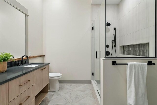 full bath with a shower stall, baseboards, toilet, and vanity