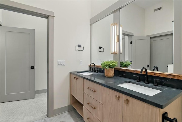 full bath with baseboards, visible vents, a sink, and double vanity