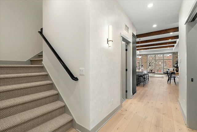 stairway featuring beam ceiling, wood-type flooring, baseboards, visible vents, and recessed lighting