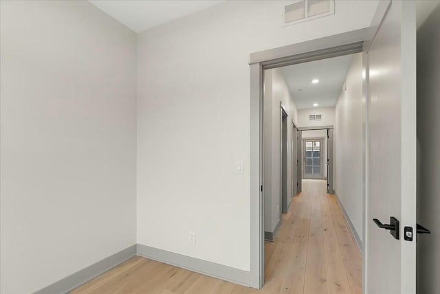 hallway with baseboards, visible vents, recessed lighting, and light wood finished floors