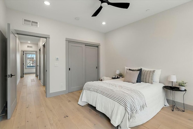 bedroom with baseboards, light wood-style floors, and visible vents