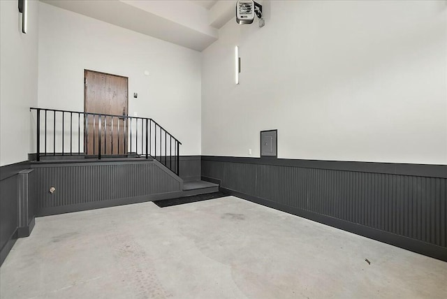 interior space with a wainscoted wall and concrete floors