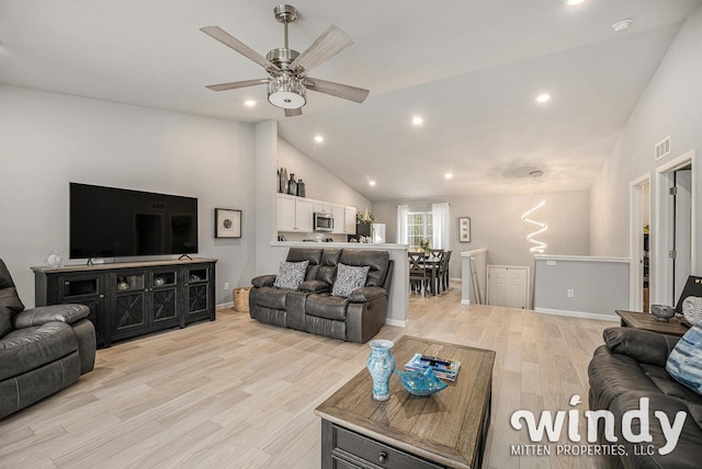 living area featuring lofted ceiling, light wood-style flooring, visible vents, and recessed lighting