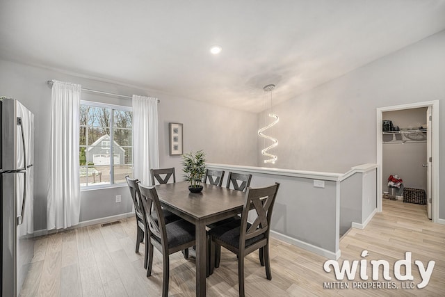 dining room featuring light wood-style floors, baseboards, and visible vents