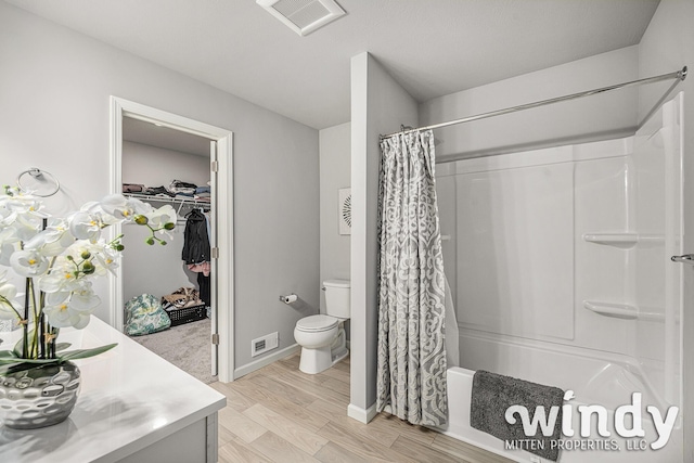 full bath featuring visible vents, shower / tub combo with curtain, toilet, and wood finished floors