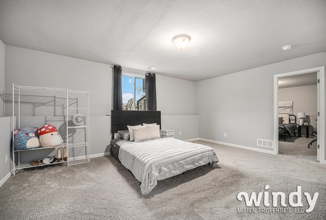 bedroom with a textured ceiling, carpet, visible vents, and baseboards